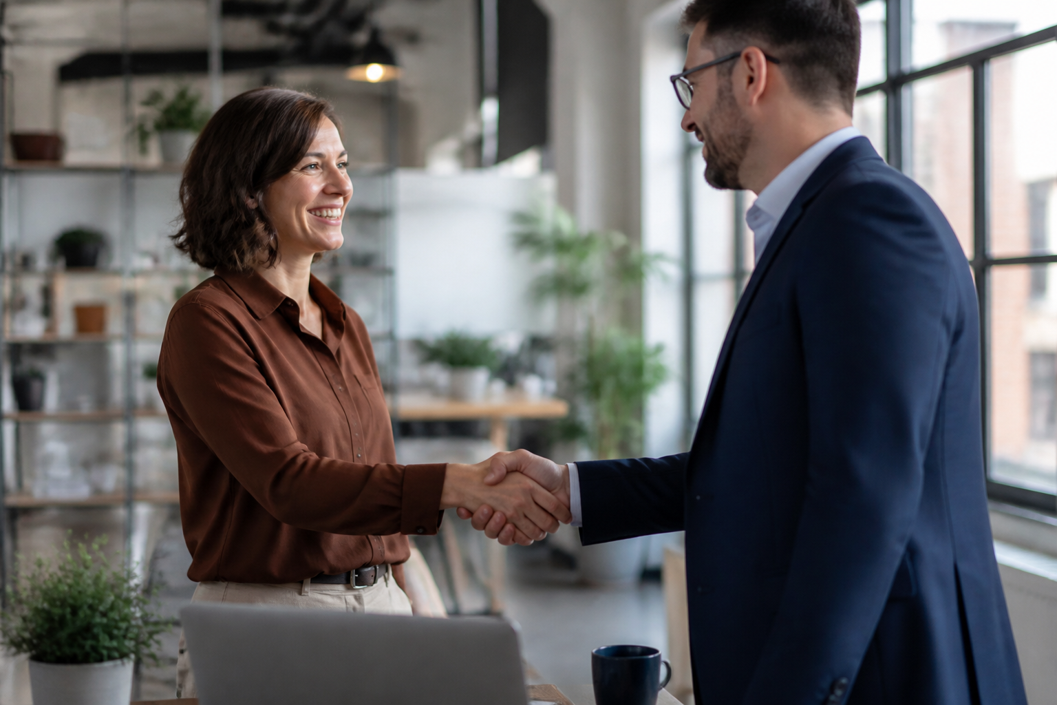 Small business owner shaking hands with an IT managed services provider representative