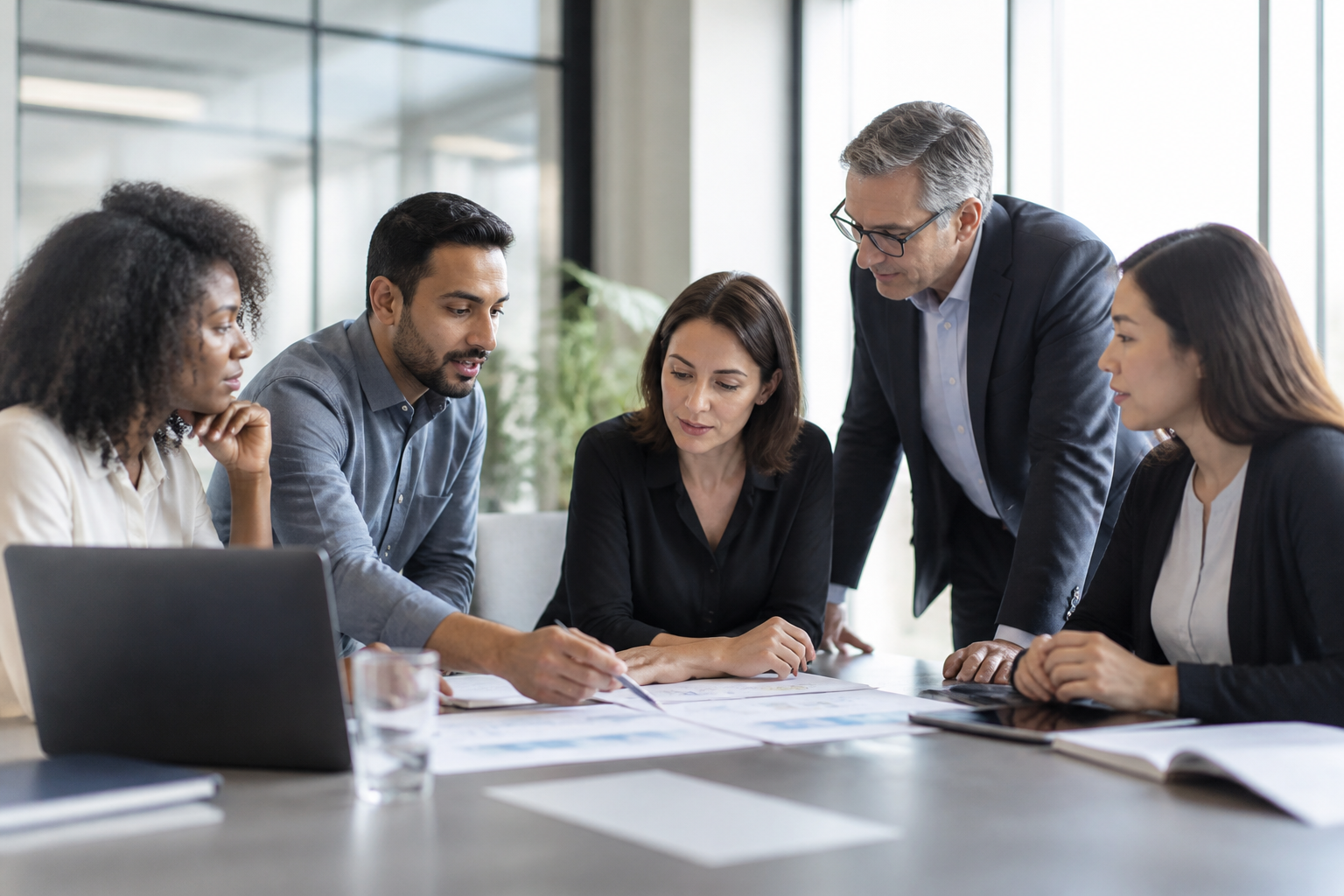 A diverse team of IT consultants collaborating on a strategic business plan with a client.